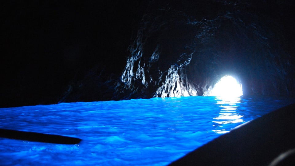 Blue light inside the Blue Grotto on Capri, with the low entrance glowing at the far end