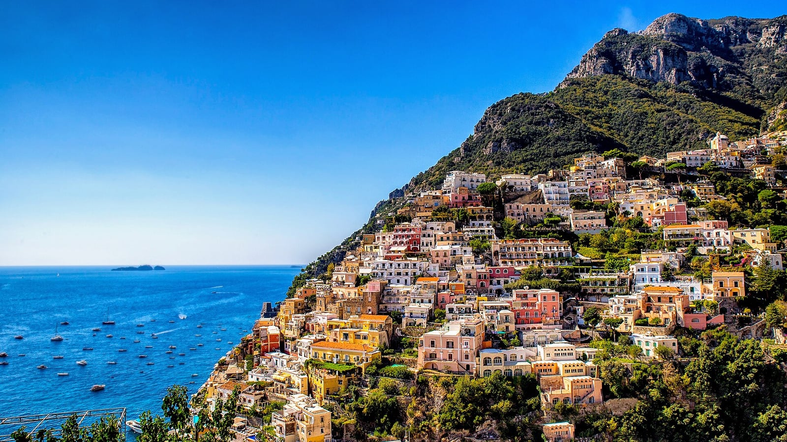 Pastel houses of Positano stacked up a steep hillside above the sea on the Amalfi Coast