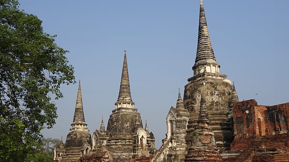 The three chedis of Wat Phra Si Sanphet rising above brick ruins in Ayutthaya