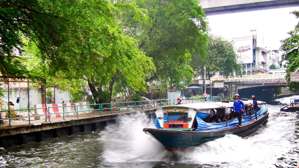 A Khlong Saen Saep express boat speeding along the tree-lined canal in central Bangkok