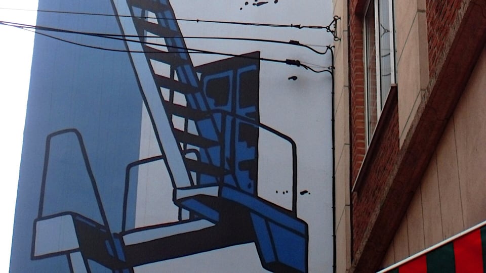 A comic-strip mural of Tintin, Snowy and Captain Haddock on a building wall in Brussels