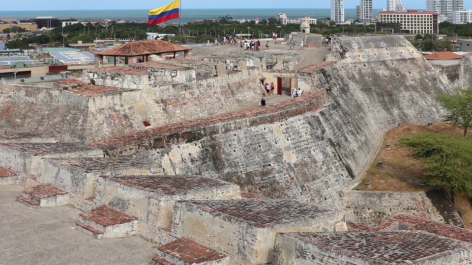 The stone ramparts of Castillo San Felipe de Barajas with the Bocagrande towers in the distance