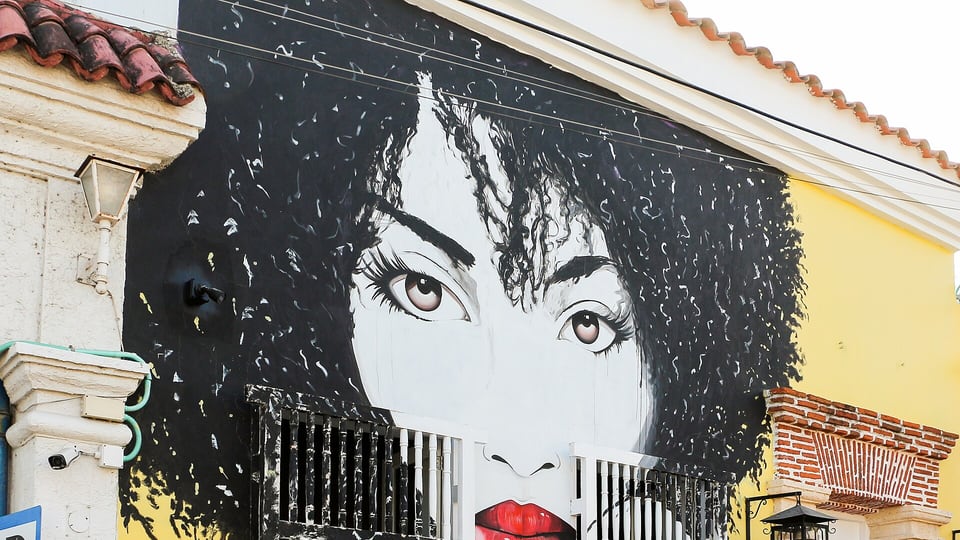 A mural of a woman painted across a colonial facade in Getsemaní, Cartagena