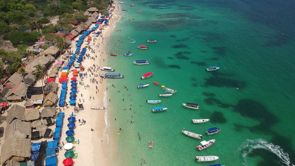 Aerial view of Playa Blanca on Barú with beach stalls, umbrellas and moored boats