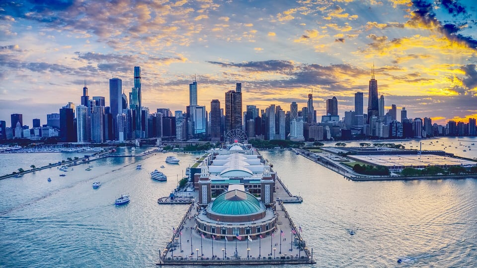 Aerial view of Navy Pier reaching into Lake Michigan with the skyline behind