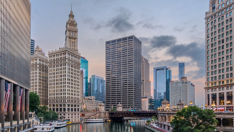 Wrigley Building and river cruise boats on the Chicago River at dusk
