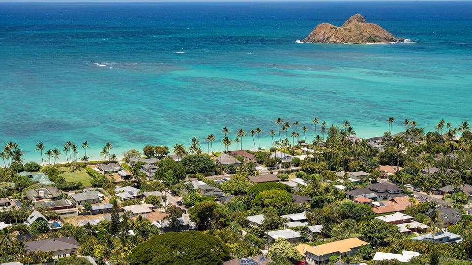 Lanikai’s shoreline and houses with an islet offshore, seen from the hill above the beach