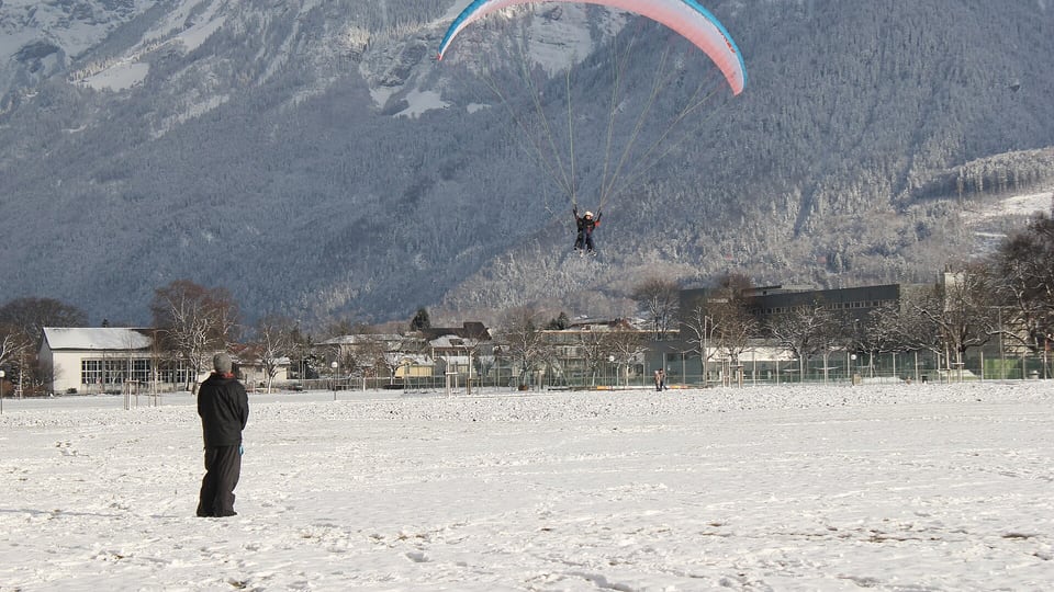 A tandem paraglider landing in Interlaken, a regulated activity under Swiss federal aviation law