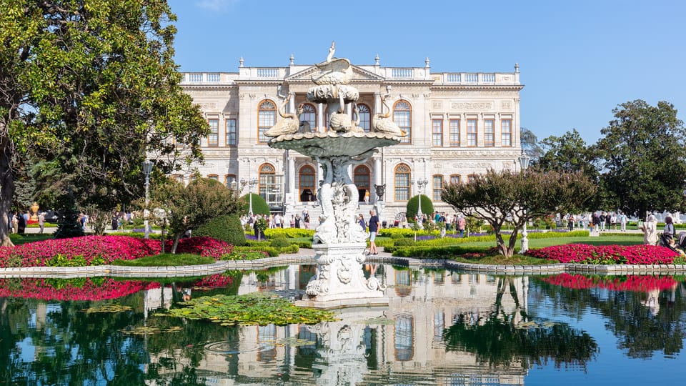 Dolmabahçe Palace behind its garden fountain and pool with flower beds, Istanbul