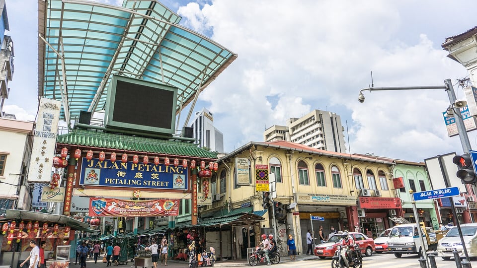 Market signs and stalls along Petaling Street in Kuala Lumpur