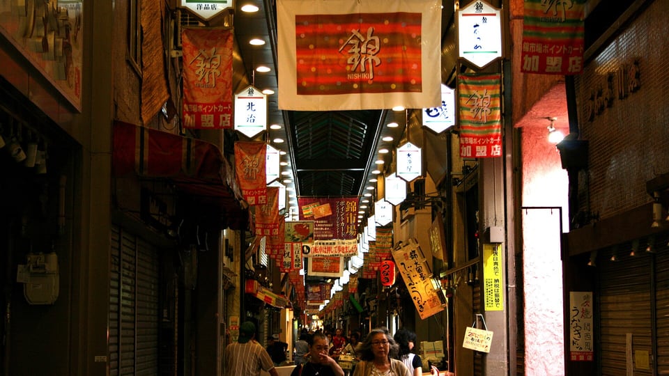 Lanterns and hanging banners inside the covered Nishiki Market arcade