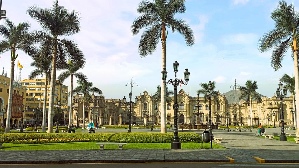 Palm trees, lamps and colonial buildings around the Plaza Mayor in Lima