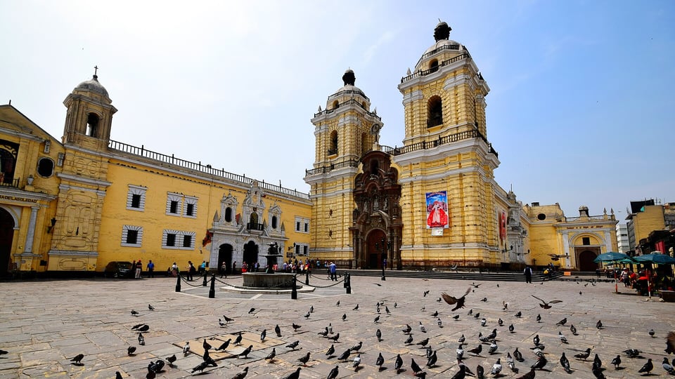 The yellow front of the Basilica and Convent of San Francisco on its plaza in Lima
