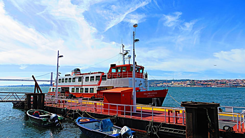An orange and white Tagus ferry moored at the pier on the Cais do Sodré to Cacilhas route