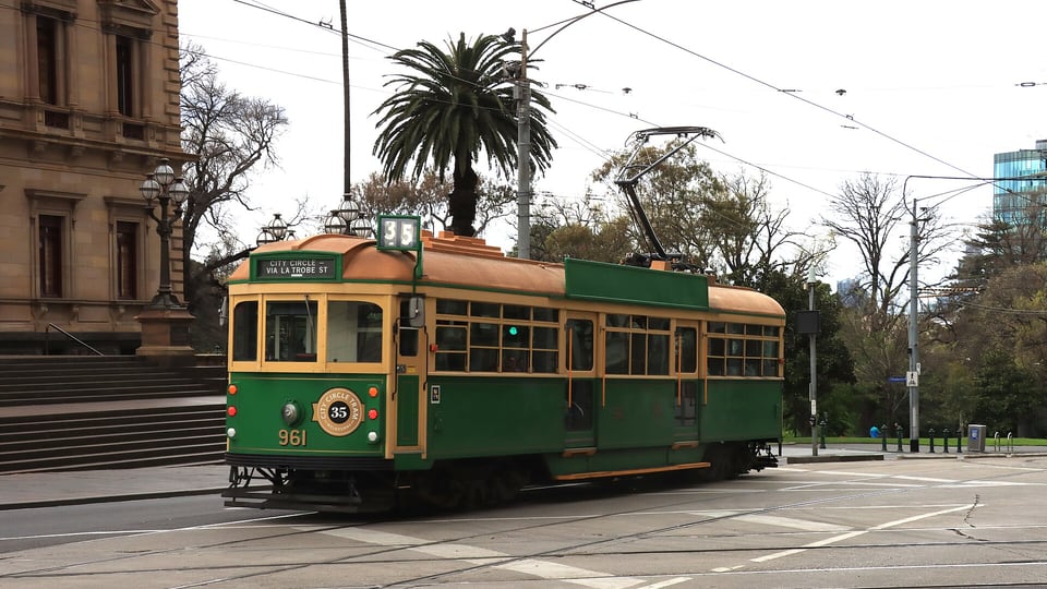 A green route 35 City Circle W-class tram crossing Collins Street at Spring Street