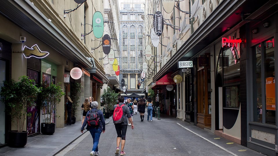 Pedestrians walking along Degraves Street between café and shop fronts