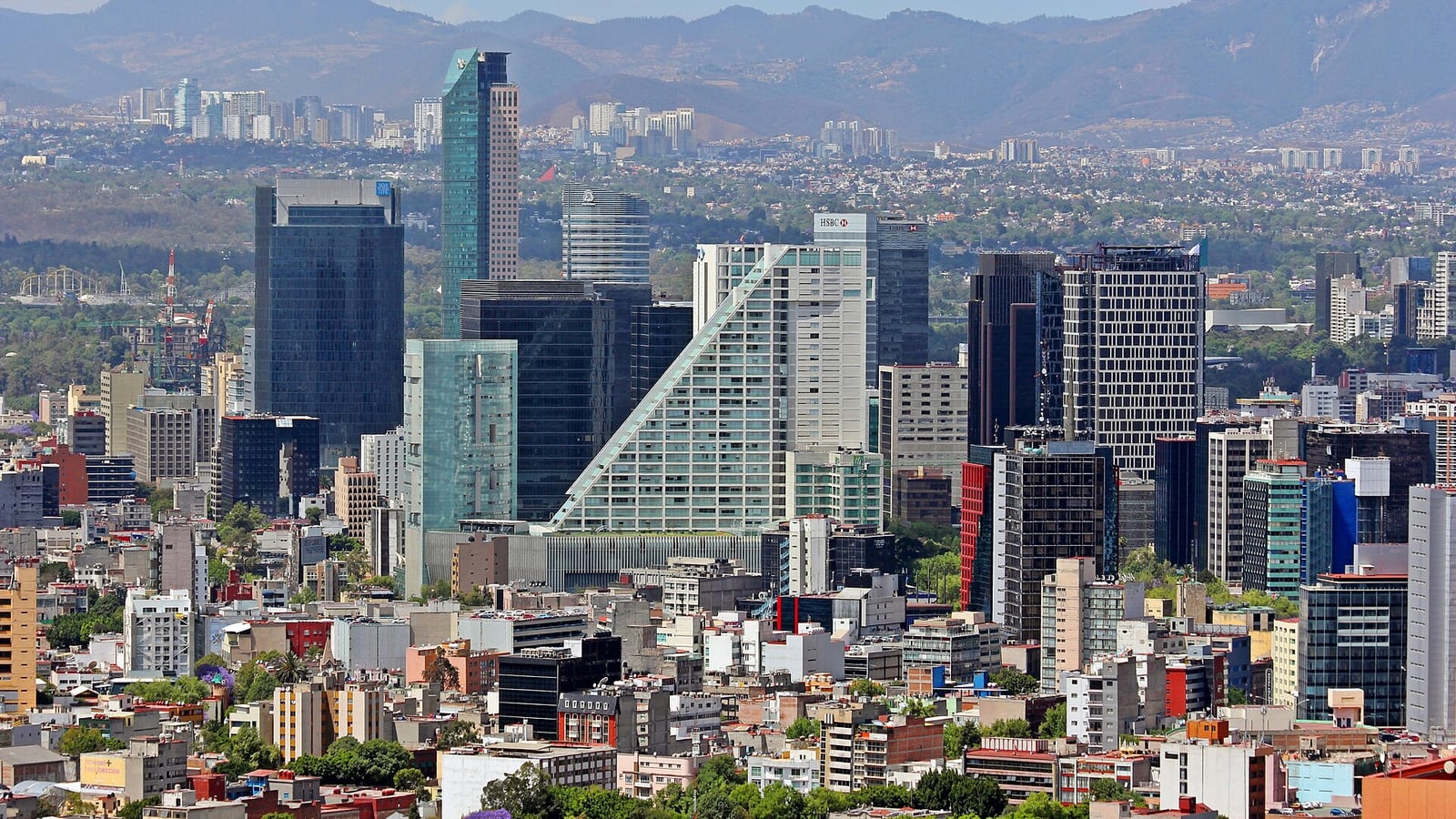 Office towers along Paseo de la Reforma with the mountains of the valley beyond