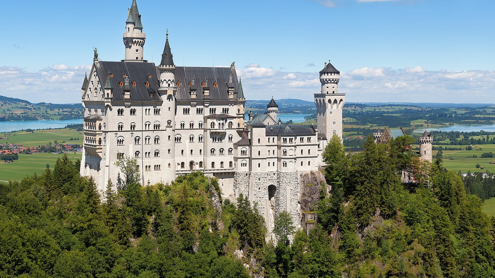 Neuschwanstein Castle on its hillside above the Bavarian Alps foothills