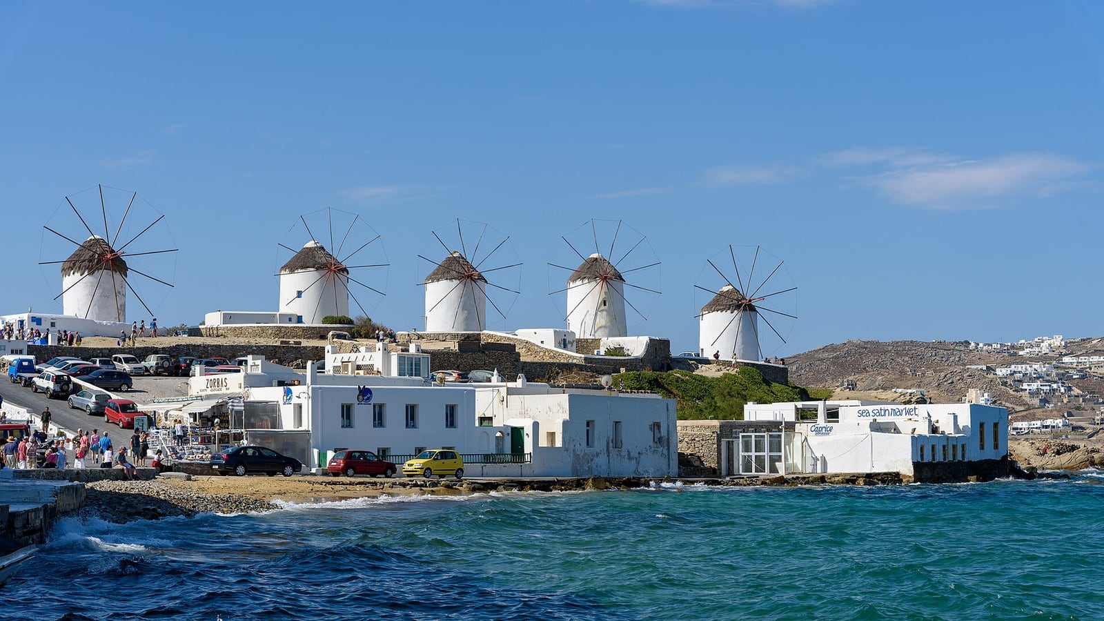 The row of white Kato Mili windmills on the ridge above Mykonos town and the sea