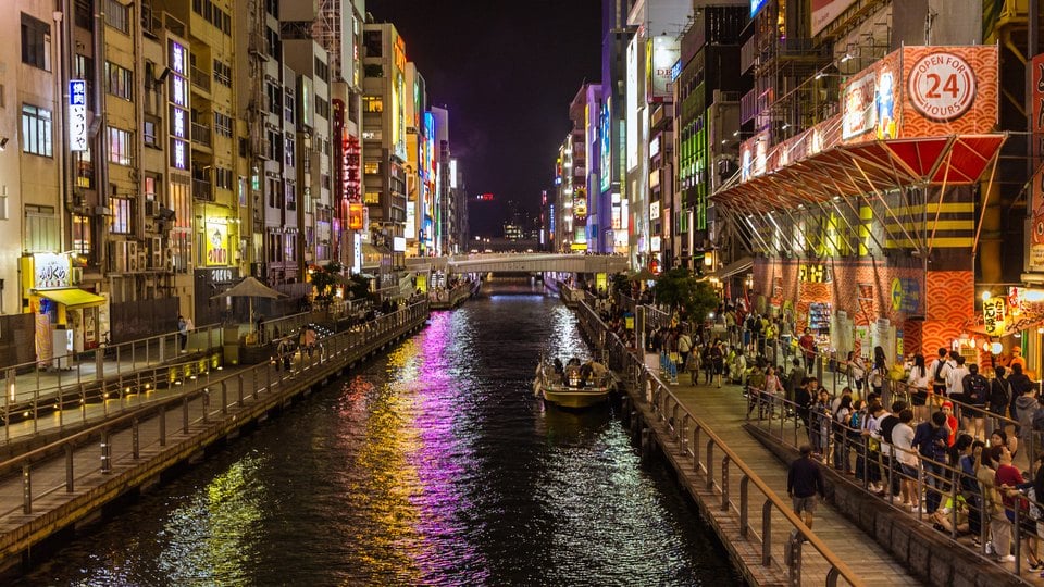 Restaurants and illuminated signs beside the Dotonbori canal at night