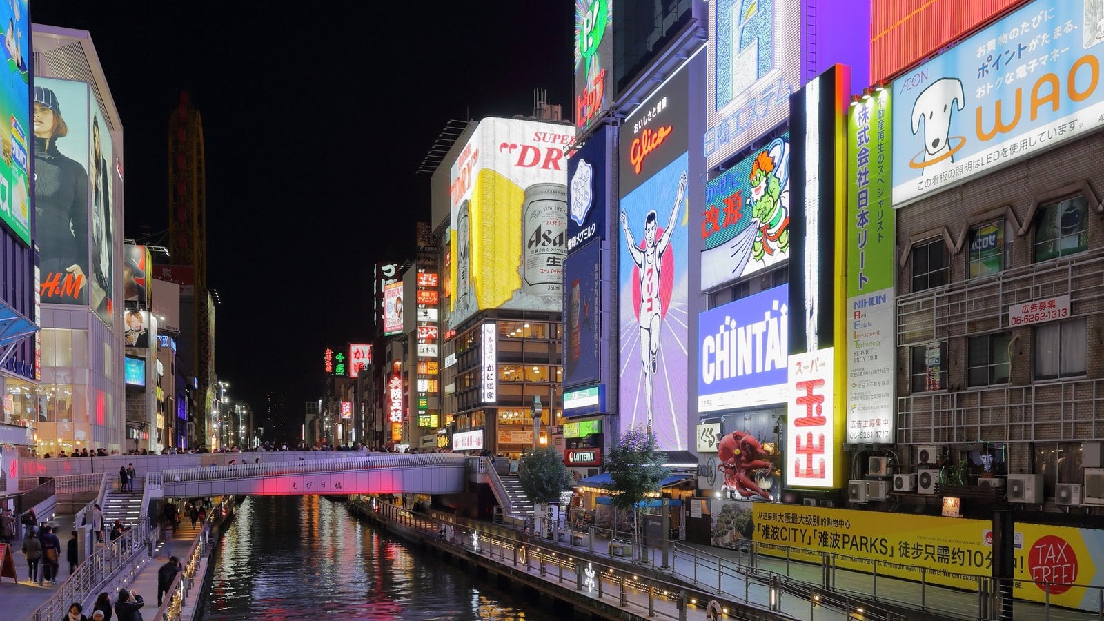 Dotonbori canal at night with illuminated buildings and a bridge in central Osaka