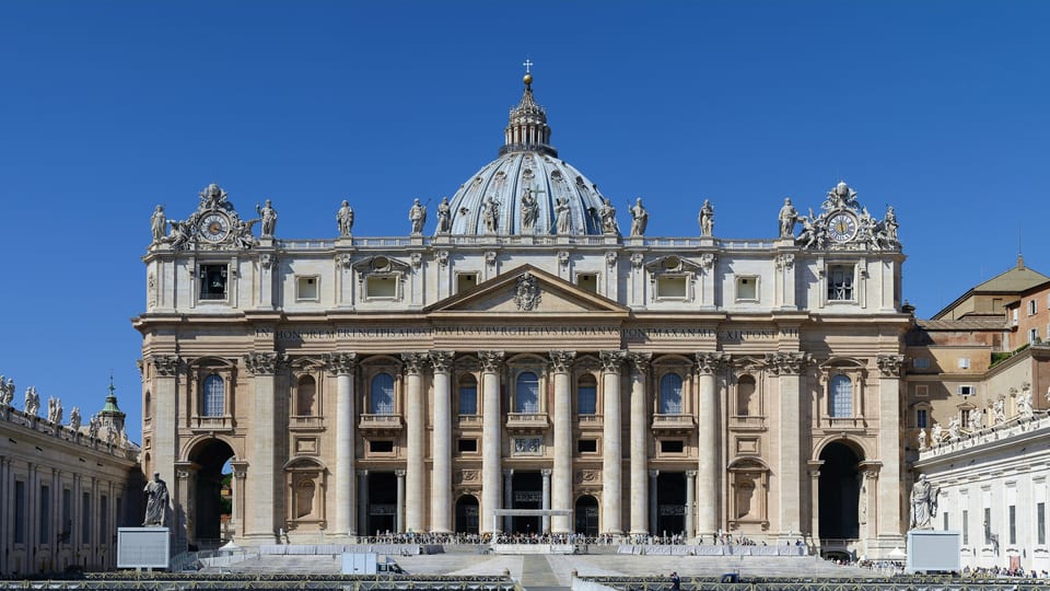 The facade of St Peter's Basilica with its dome rising behind, seen from St Peter's Square