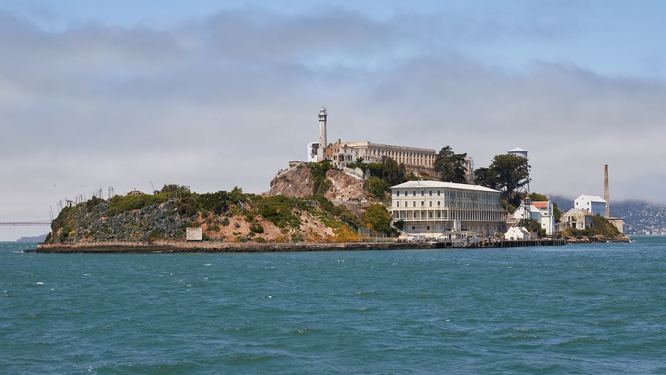 Alcatraz Island with its cellhouse and lighthouse, seen across the bay