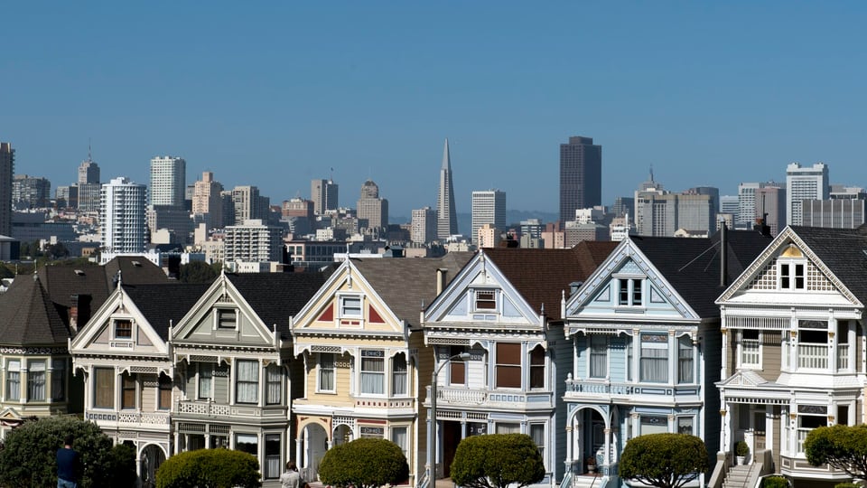 The row of Victorian houses on Steiner Street with the downtown skyline behind
