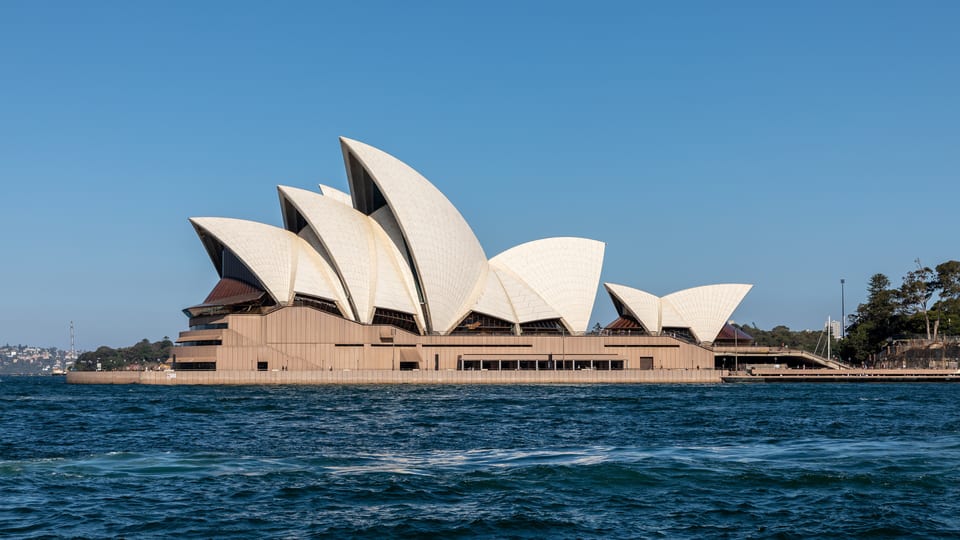 The white roof shells of the Sydney Opera House on Bennelong Point seen across the harbour