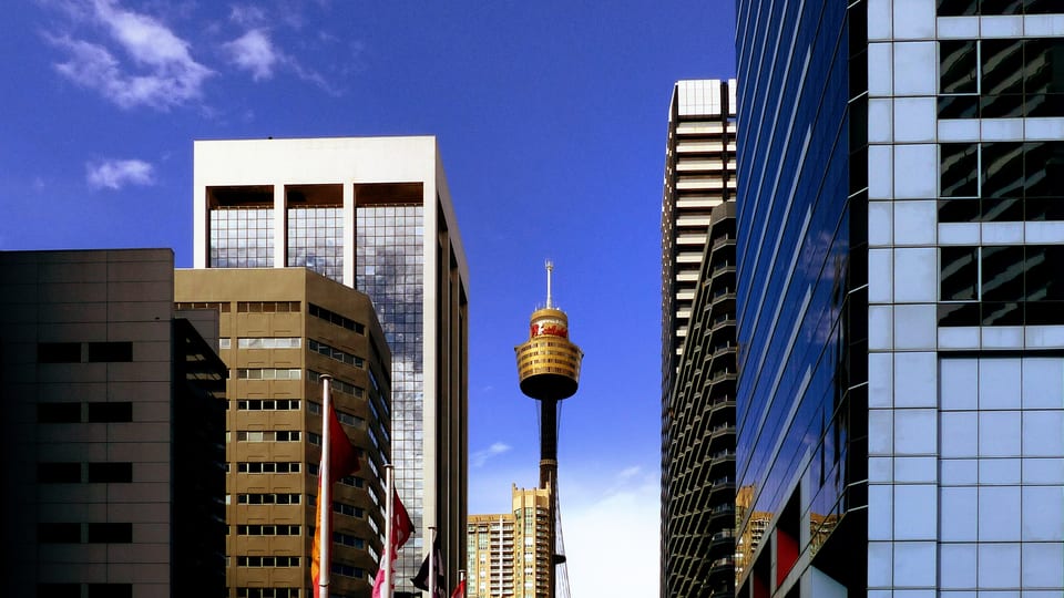 Sydney Tower rising between office buildings in the Sydney CBD