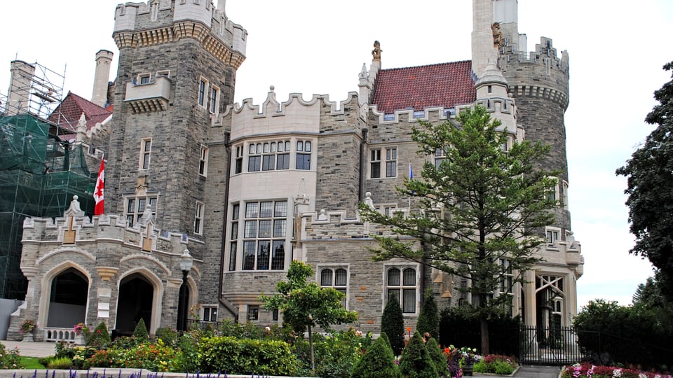 The stone towers and Gothic Revival facade of Casa Loma above its front garden in Toronto