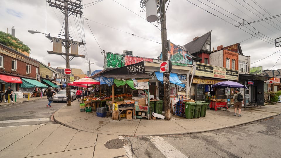 Produce stalls and painted shopfronts at the corner of Augusta Avenue and Baldwin Street in Kensington Market