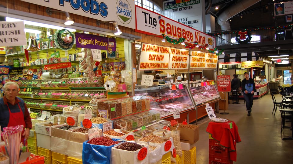 Food stalls with produce, nuts and deli counters inside St. Lawrence Market in Toronto