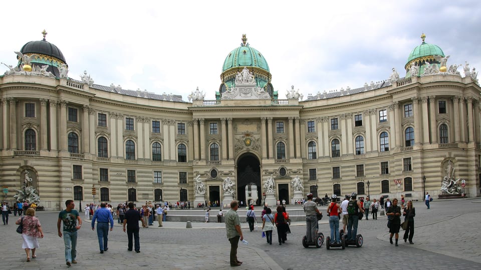 The Michaelertrakt wing of the Hofburg in Vienna with its green domes and entrance gate, seen from Michaelerplatz