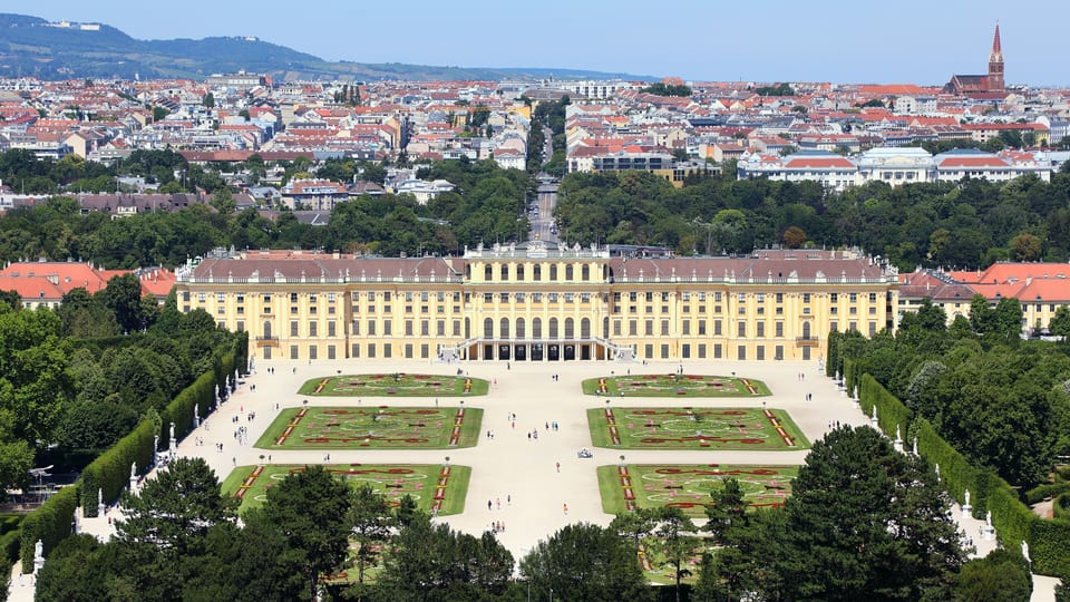 Schönbrunn Palace and its formal parterre gardens seen from the Gloriette hill, with Vienna stretching behind