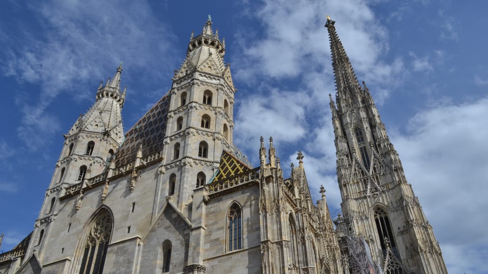 The Gothic west front and South Tower spire of St. Stephen's Cathedral in Vienna against a cloudy sky